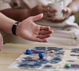 Spelers gooien met dobbelstenen tijdens een bordspelsessie, waarbij de interactieve gameplay en strategie centraal staan.